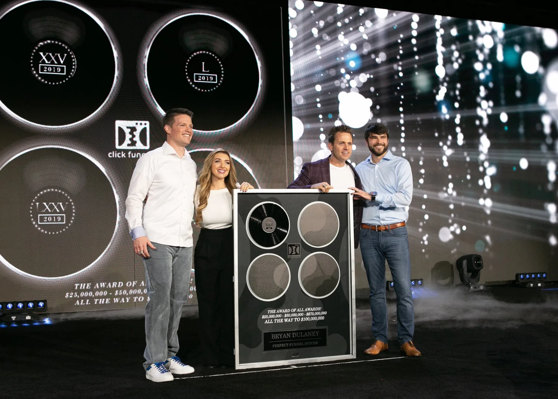 Bryan and Stephanie Dulaney on stage receiving the ClickFunnels Award of All Awards